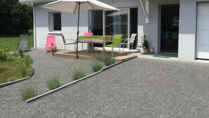 A modern house with a tiled roof, a covered patio with a table and chairs, and a small garden area. - Bassin d'arcachon, a cozy little nest between dune du pyla and cap-ferret  (Audenge)
