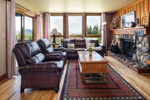 A cozy living room with leather sofas, a wooden coffee table, and a stone fireplace. - Outpost: Nez Perce A3 - Hot Tub Access! (Teton Village)