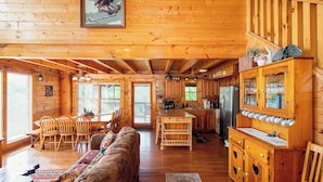 A cabin interior with a dining area, kitchen, and a wooden ceiling. - A+ Views & Location! > Parkway, Dollywood. Theater, Hot Tub, Games, Pet Friendly (Pigeon Forge)