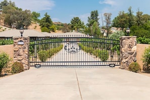 entrance to a residential property with a decorative emblem and stone pillars.