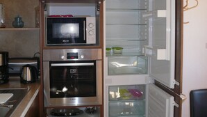 Una cocina compacta con microondas, horno y refrigerador integrados.