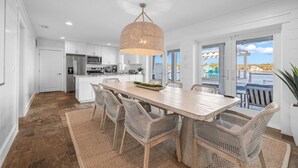 A modern kitchen with white cabinets, stainless steel appliances, and a large island. - Lake Front w/ Dock, Kayaks and Pool (Santa Rosa Beach)