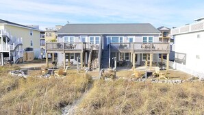 A beachfront building with multiple balconies and a central staircase.
