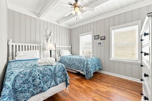 A bedroom with two beds, a ceiling fan, and a window with blinds. - Direct Oceanfront House Ocean and Pier Views (North Myrtle Beach)