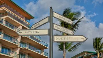 A signpost with directions to various locations including 'Real Estate Sales', 'Aina Gouri Market', 'Ho'ola Spa', and 'Duke's Beach House'.