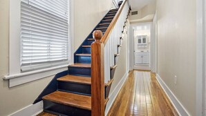 A staircase with wooden steps and a wooden handrail, leading to a door at the top. - Downtown dog-friendly 4 bedroom house, walk everywhere, free parking (St Augustine)