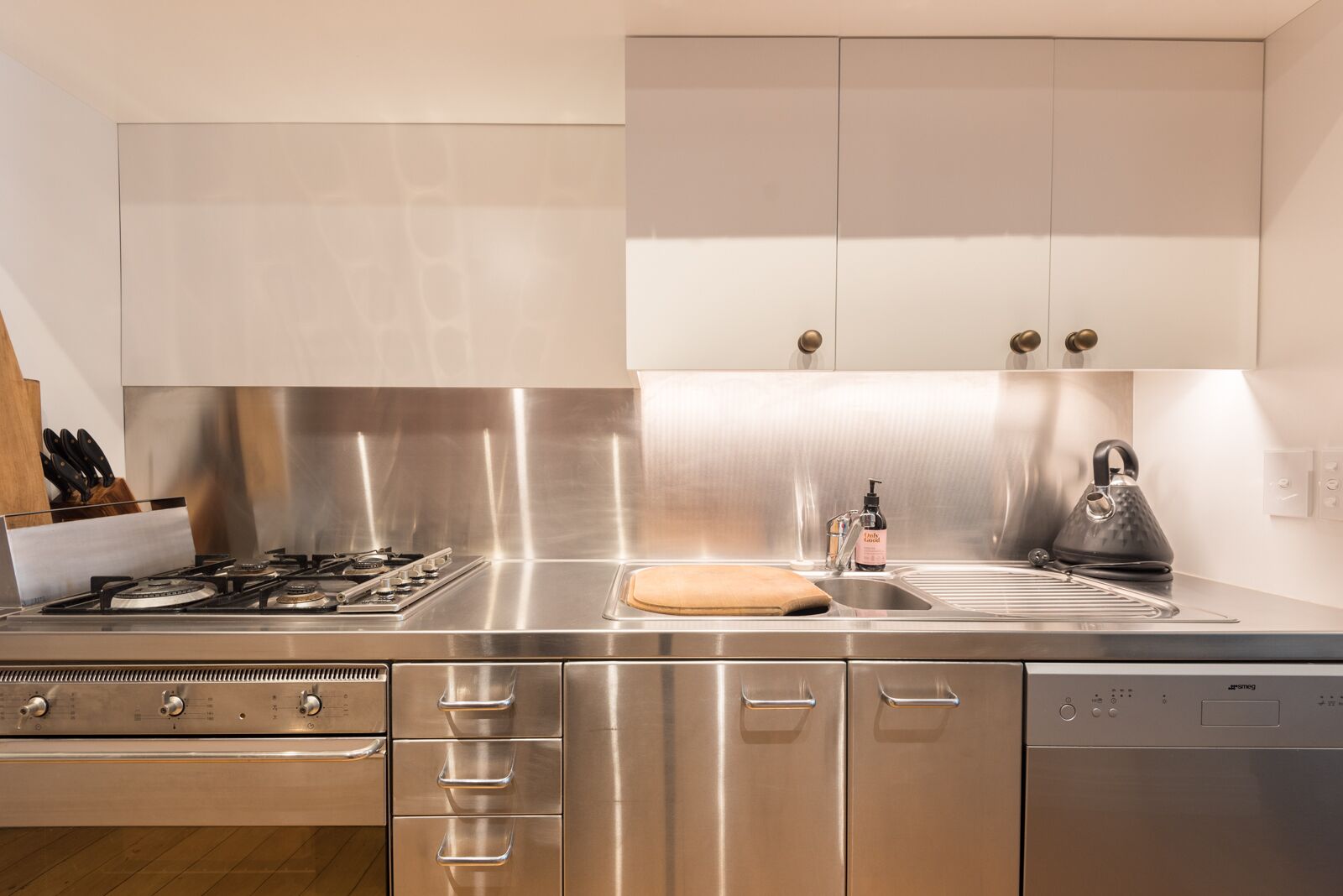 Eine moderne Küche mit Edelstahlgeräten, einem Backofen und einem Geschirrspüler.
