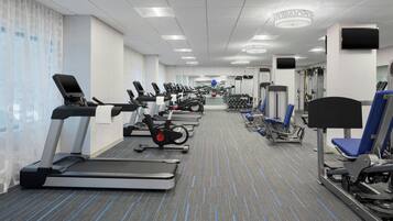 A gym with treadmills, elliptical machines, and weight equipment.
