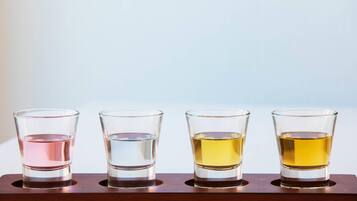 Cuatro vasos para shots sobre una bandeja de madera.