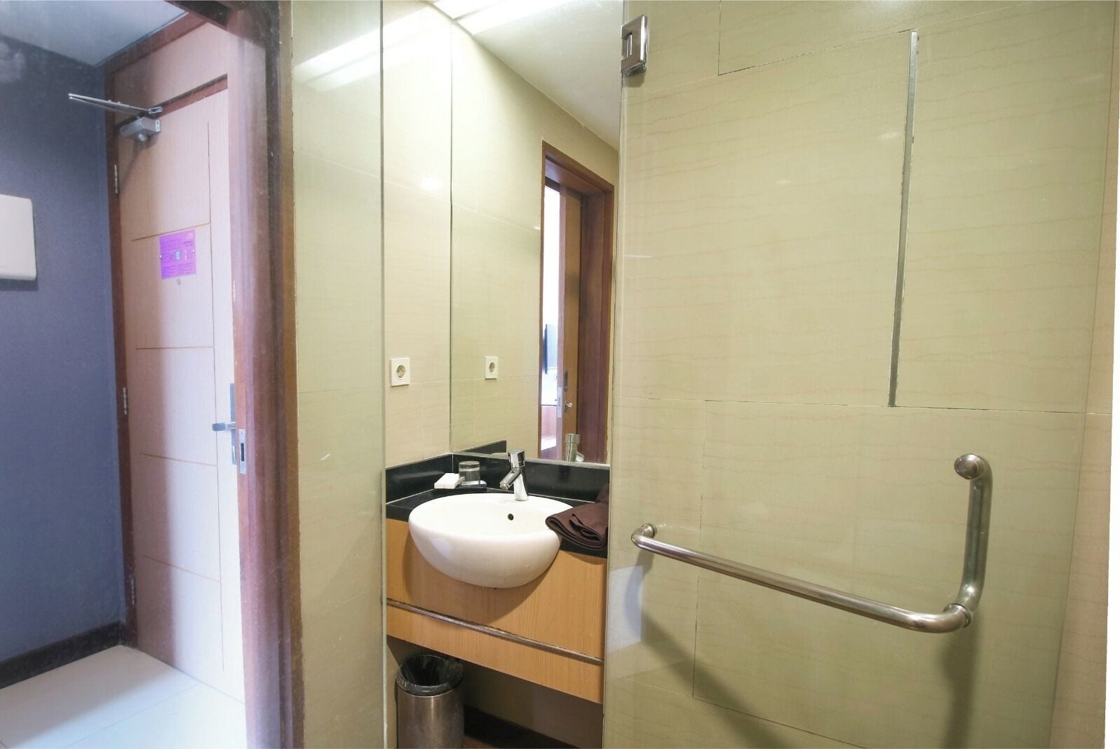 A bathroom with a sink, mirror, and a shower area.