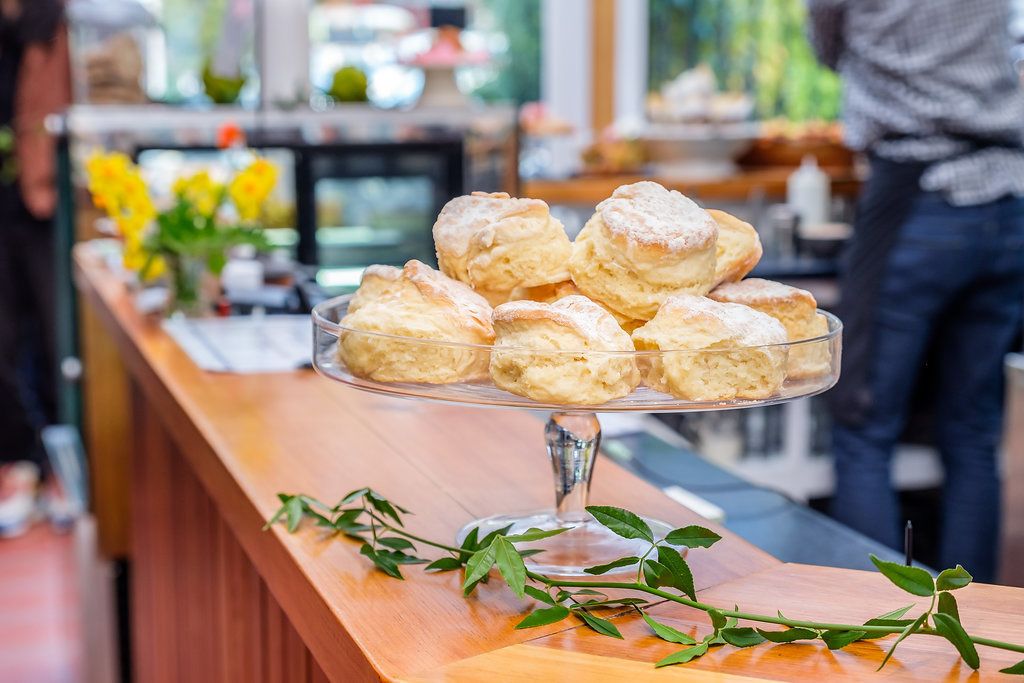 A buffet table with a glass stand holding several pastries.