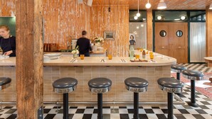Un espace bar avec des tabourets, un comptoir et un plafond en bois.