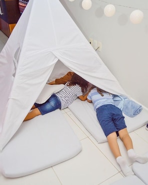 A tent-like structure with two people inside, a white floor, and string lights on the wall. - Blue Tree Towers Sao Luis (São Luís)