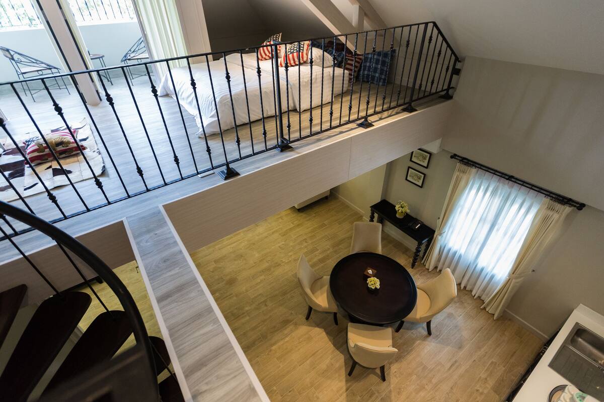 A multi-level apartment with a dining area, kitchen, and a balcony with a railing.
