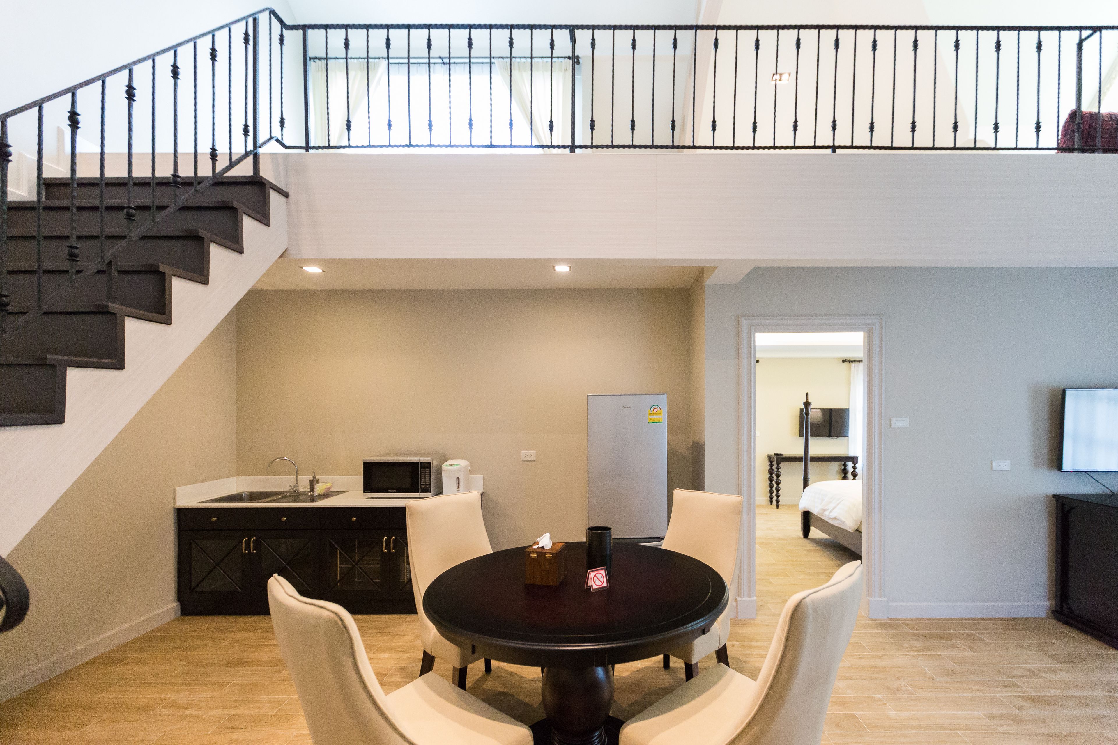 Un appartement moderne comprenant une cuisine, un coin repas et un escalier menant à un niveau supérieur.