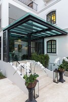 A modern building with a glass entrance, a staircase, and potted plants.
