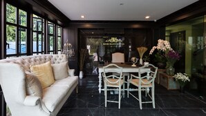 Um quarto luxuoso com uma janela ampla, um sofá confortável, uma mesa de jantar com cadeiras e vista para o exterior.