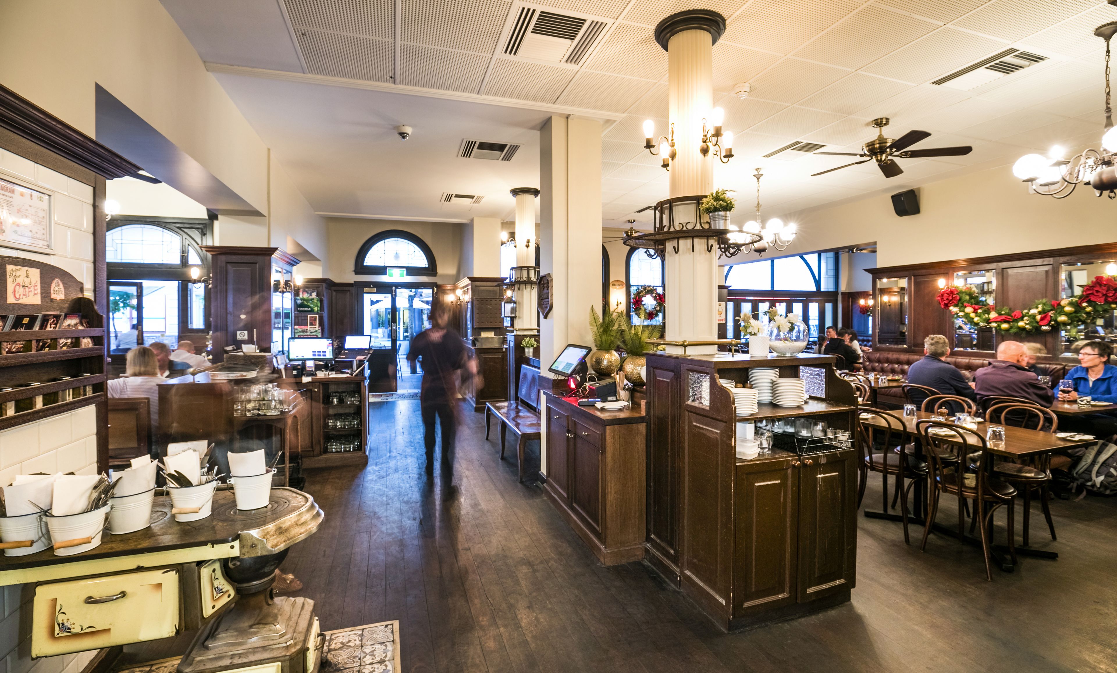 A restaurant interior with a bar area, seating, and a view of the street.
