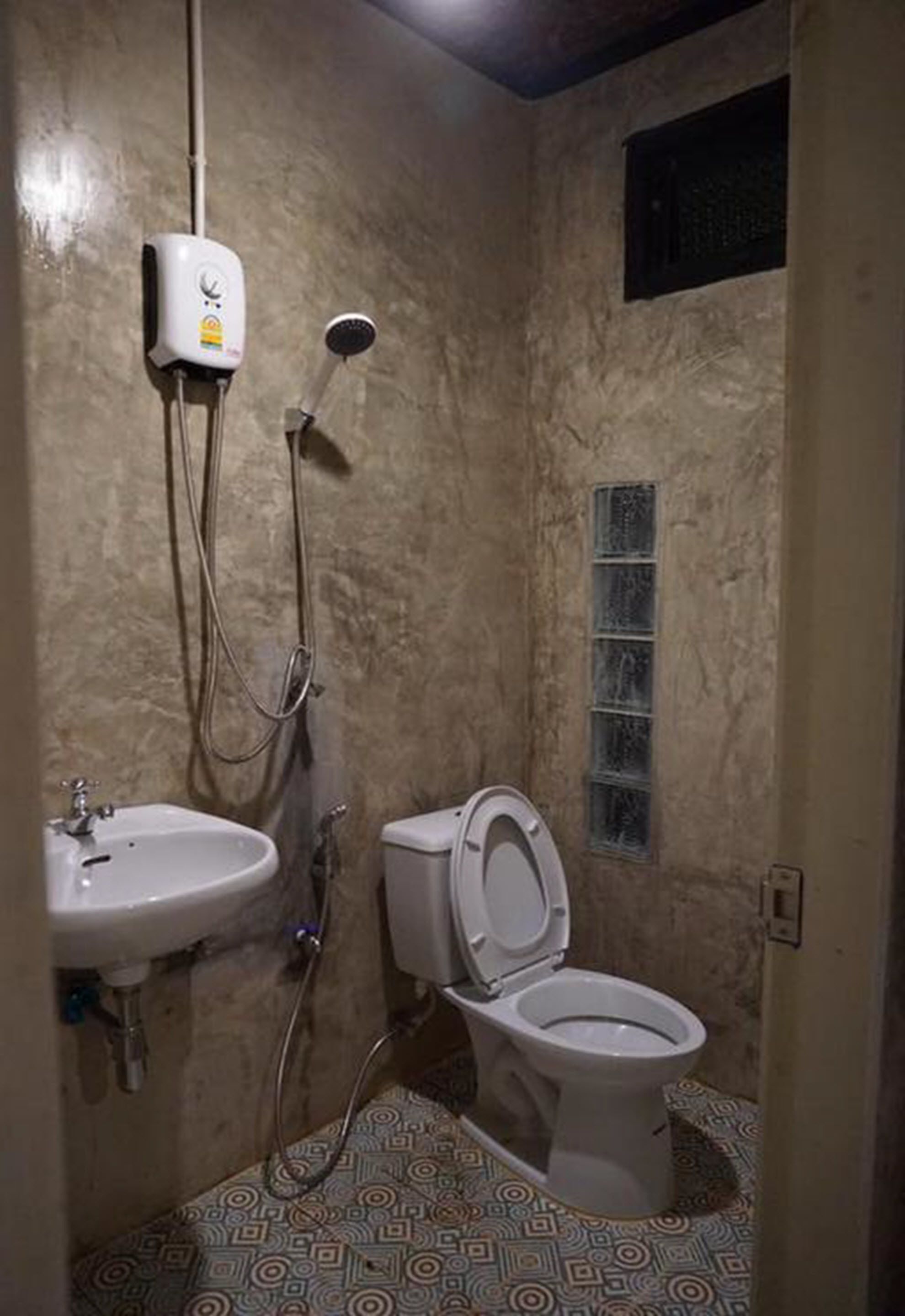 A bathroom with a toilet, sink, and shower.