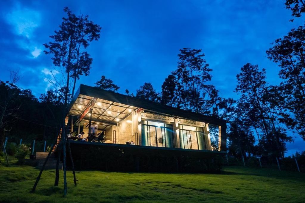 A modern house with a flat roof, large windows, and a well-lit interior.