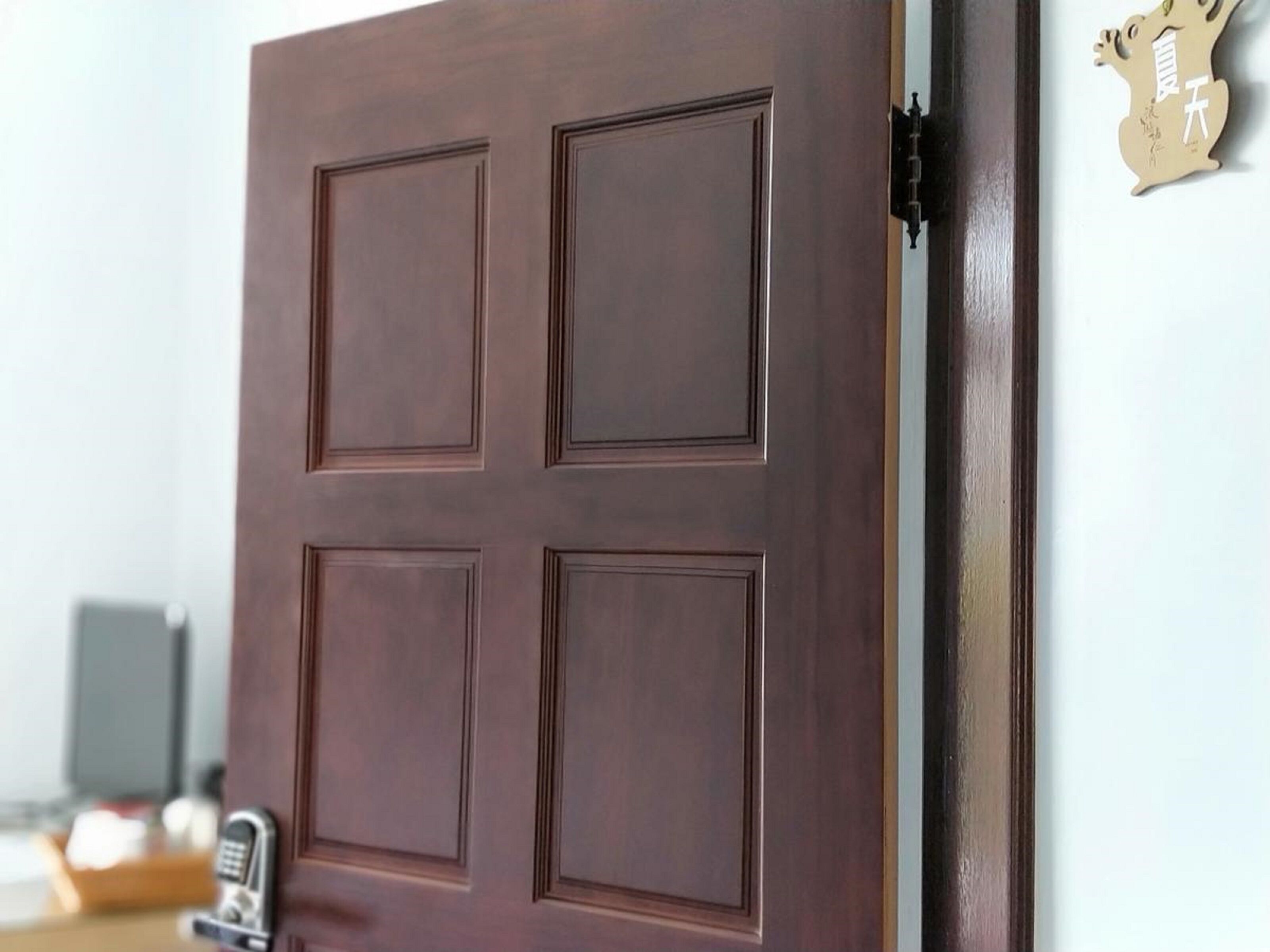 Una puerta de madera cerrada con un ojo de cerradura y un timbre.