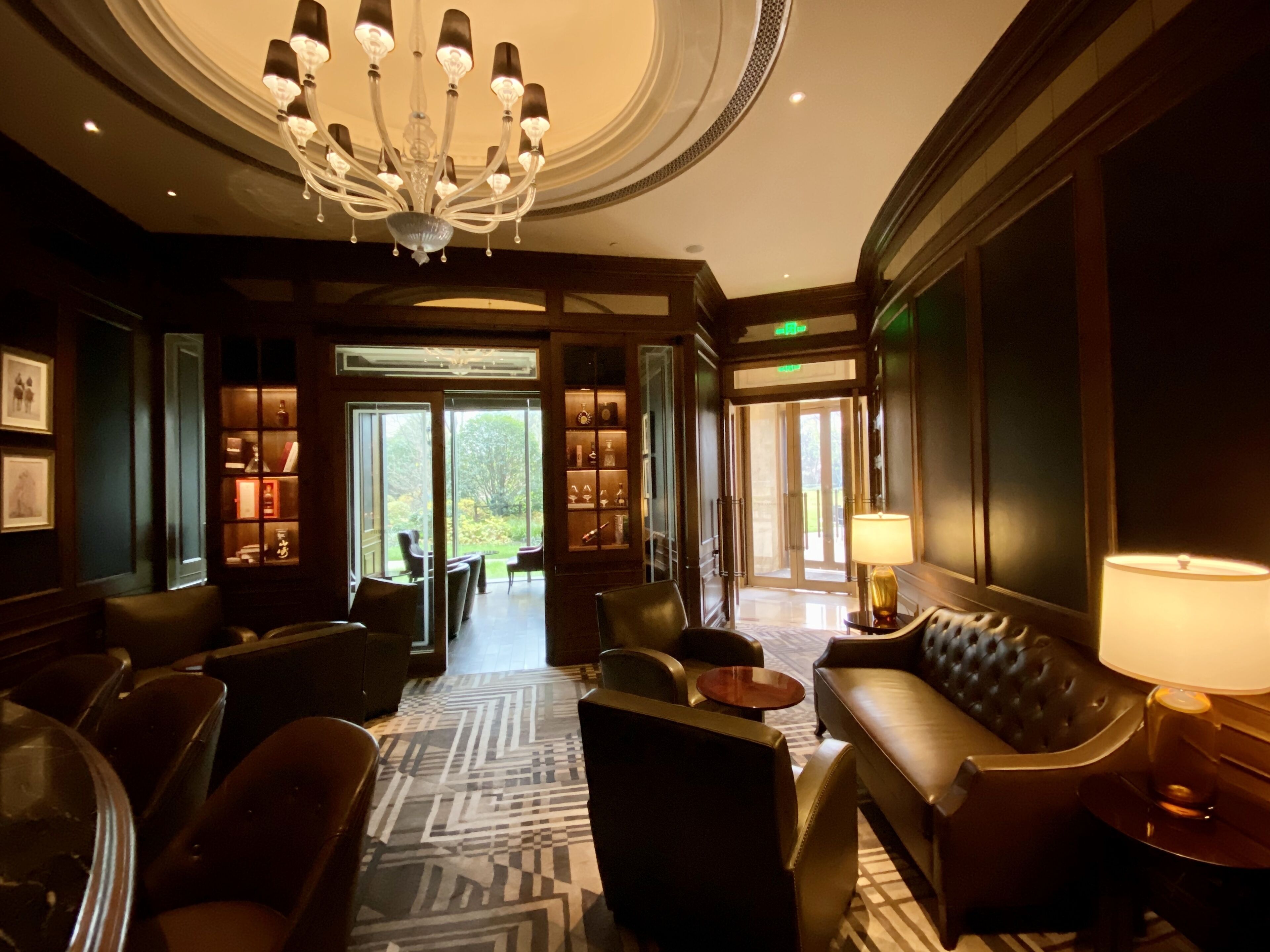A spacious lobby with a chandelier, leather seating, and a patterned carpet.