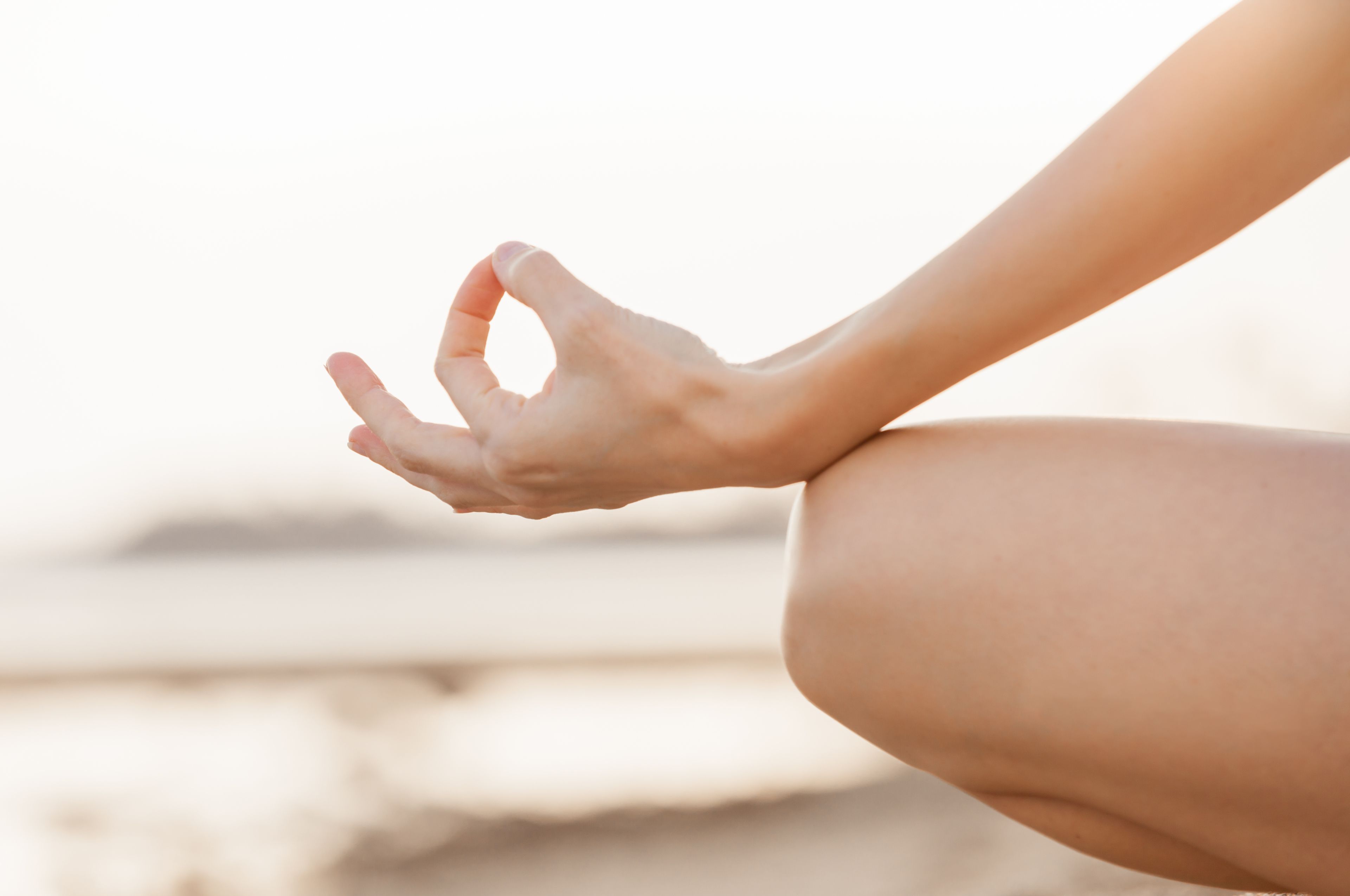 Una persona seduta con le mani in posizione meditativa.