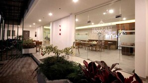 An indoor restaurant with a modern design, featuring a glass wall and a sign that reads "THREE EIGHTH FROM ONE." - Three Eight Front One Boutique Batu (Batu)