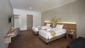 A hotel room with two beds, a desk with a fruit bowl, a mirror, and a small plant. - Three Eight Front One Boutique Batu (Batu)