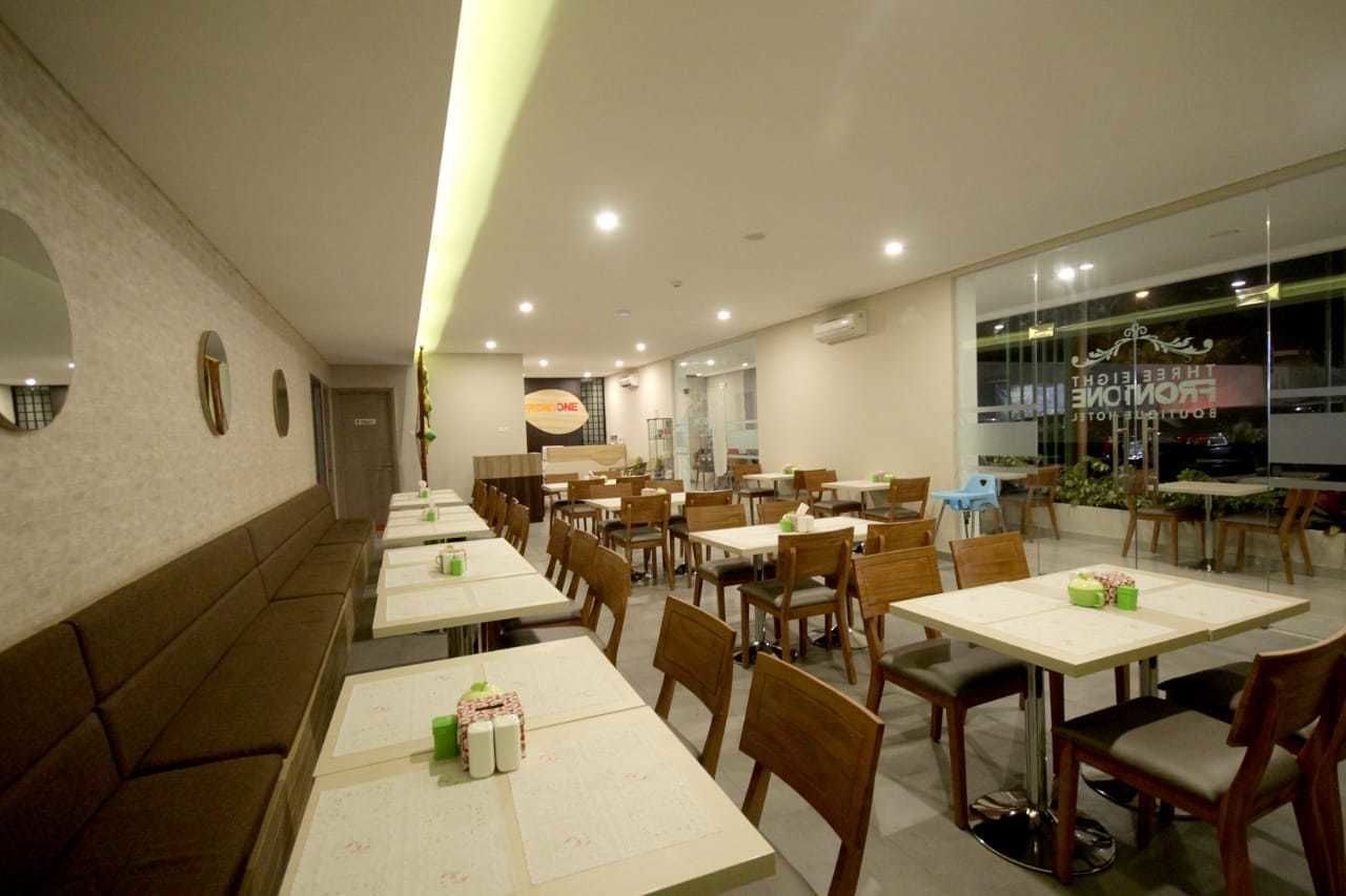 Un restaurante con varias mesas, cabinas y un mostrador con la carta, además de un muro de vidrio con señalización.