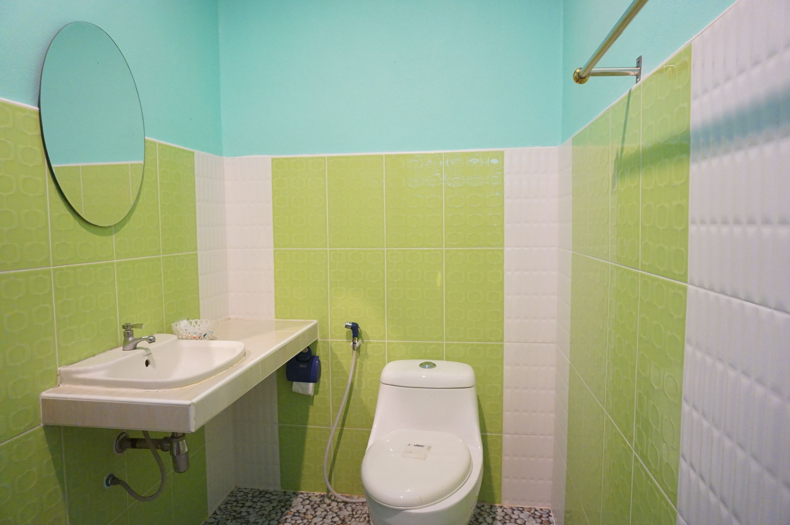 A bathroom with a sink, toilet, and mirror.
