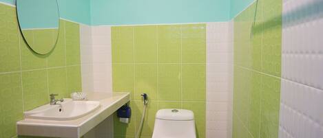A bathroom with a sink, toilet, and mirror.