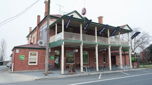 A two-story building with a balcony, a sign for 'Riverina Hotel', and a 'Dining Room' sign. - Riverina Hotel (Holbrook)