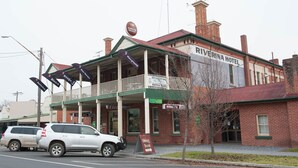 A two-story building with a balcony, signs for 'Riverina Hotel' and 'Bottle Shop', and a 'Dining Room' sign. - Riverina Hotel (Holbrook)