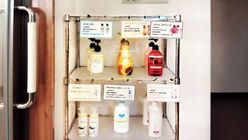 A shelf with various toiletries including Dove, Lotus, and other brands, with labels in Japanese.