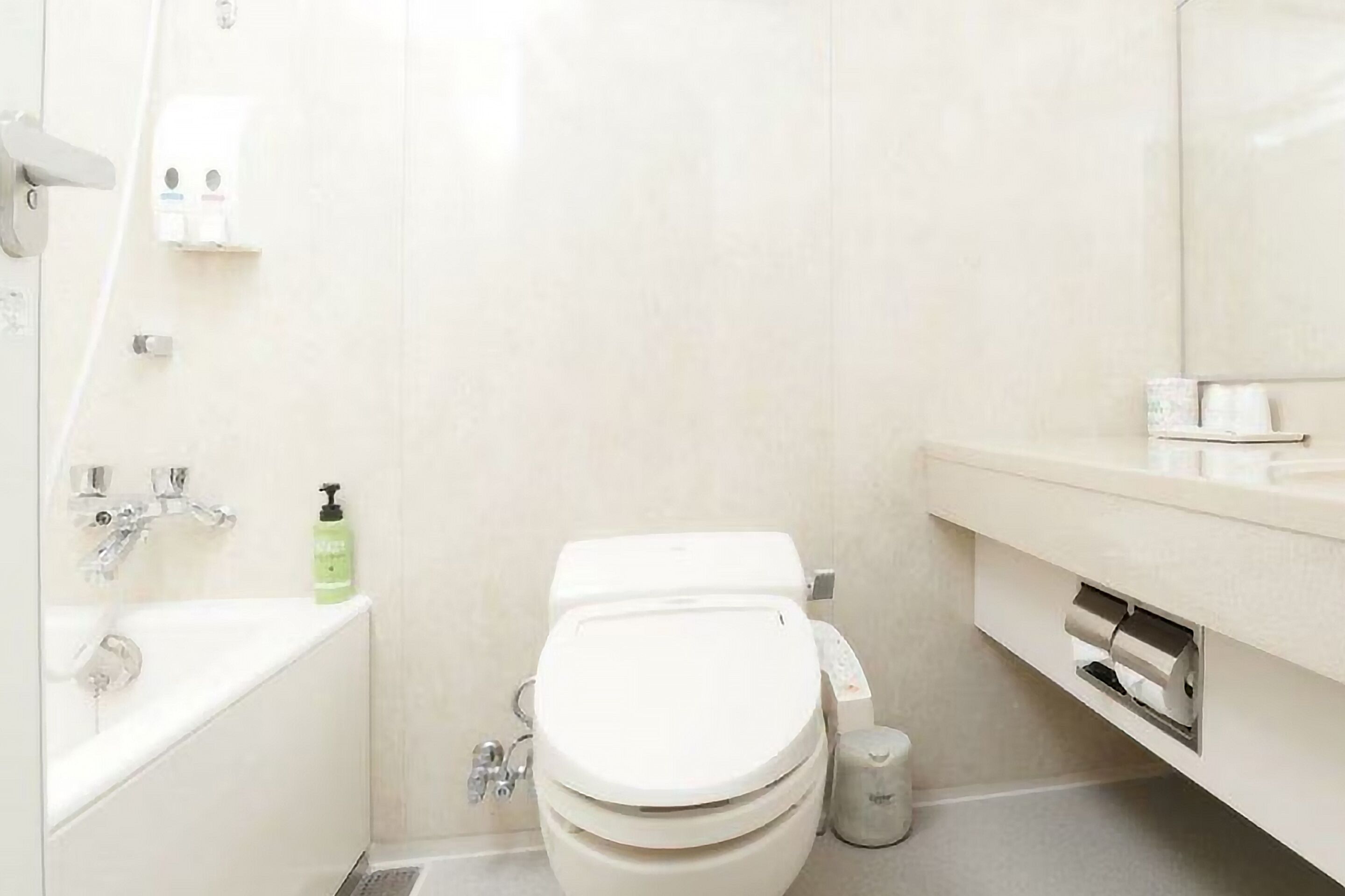 A modern bathroom with a white toilet, a sink, and a mirror.