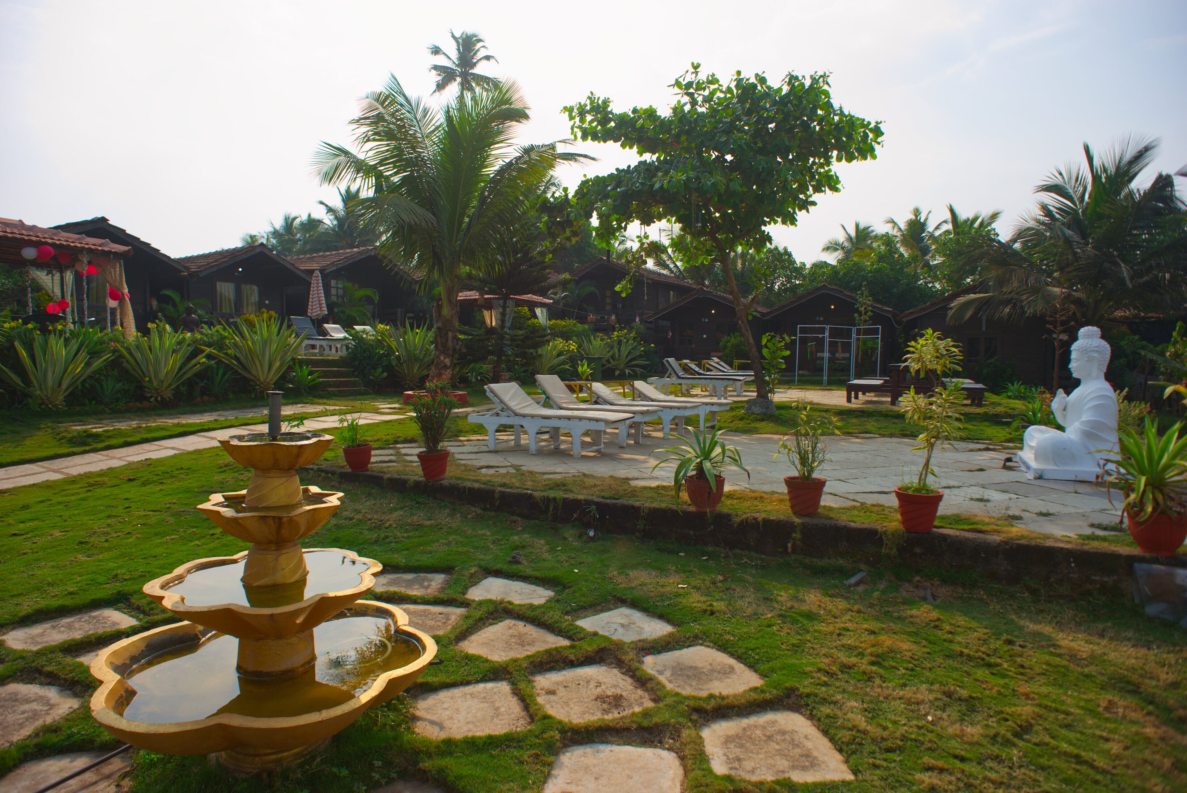 Un complexe hôtelier doté d’une piscine, de chaises longues et d’une statue.