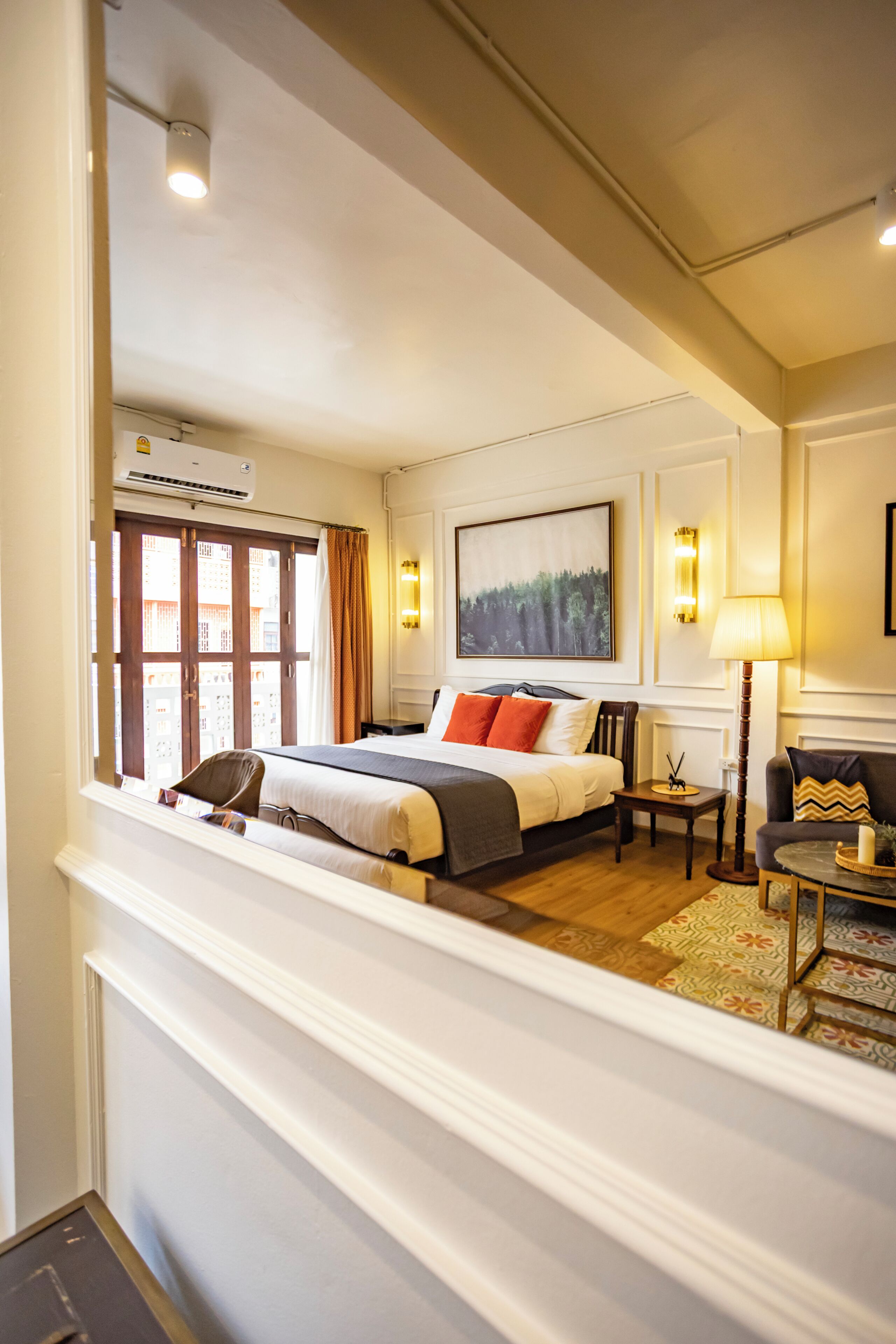 Une chambre d’hôtel avec un lit, une table de chevet, une lampe et un tableau au mur.