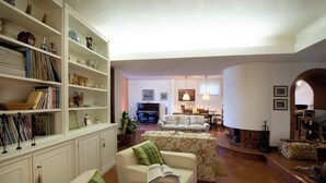 Ein geräumiges Wohnzimmer mit Kamin, Bücherregal und Essbereich.