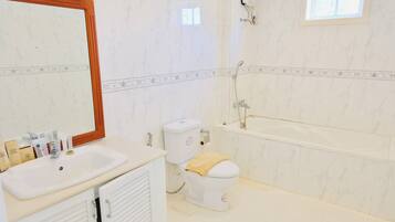 Un bagno con lavandino, WC e vasca da bagno bianchi.