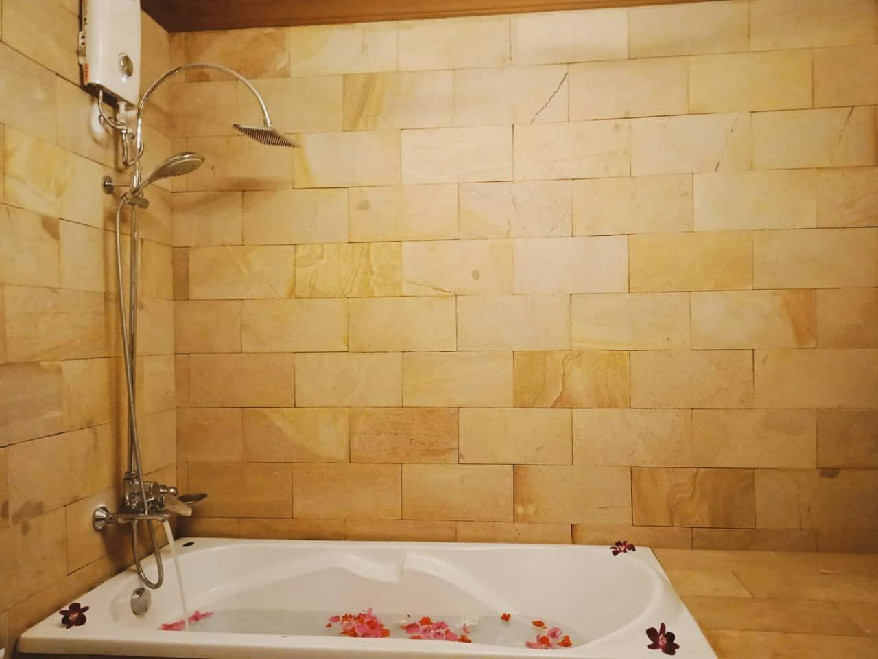 Un baño con bañera, ducha y paredes de azulejos.