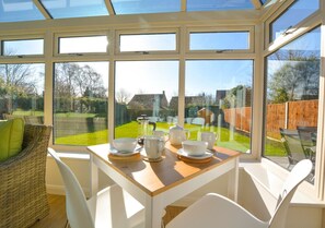 Enjoy dining or tea in this serene conservatory with a beautiful garden view.
