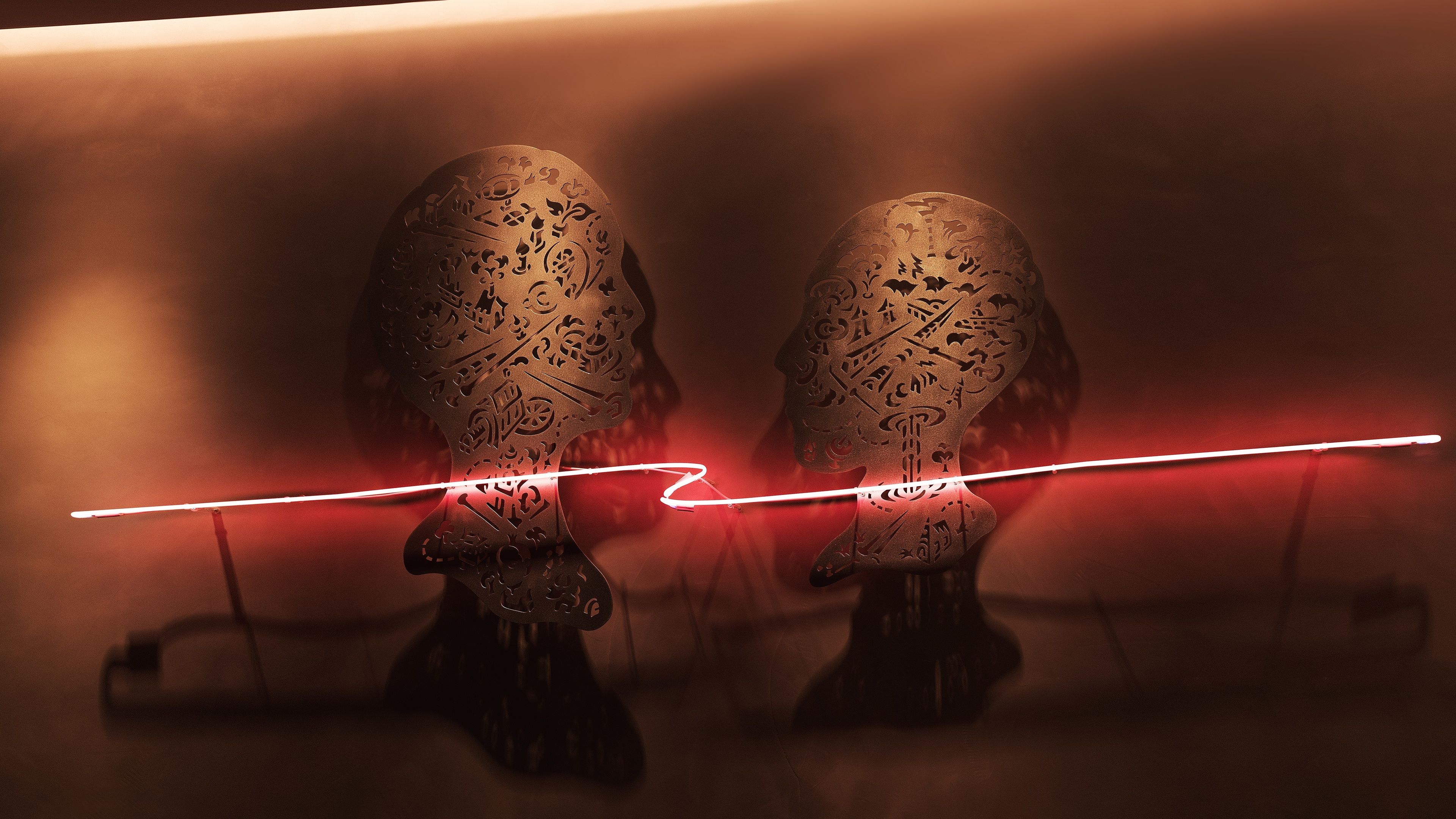 Deux sculptures richement décorées, séparées par un faisceau de lumière rouge.