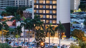 A modern hotel building with multiple floors, a prominent sign, and a parking lot with several cars. - Brio Hotel (Kaohsiung)