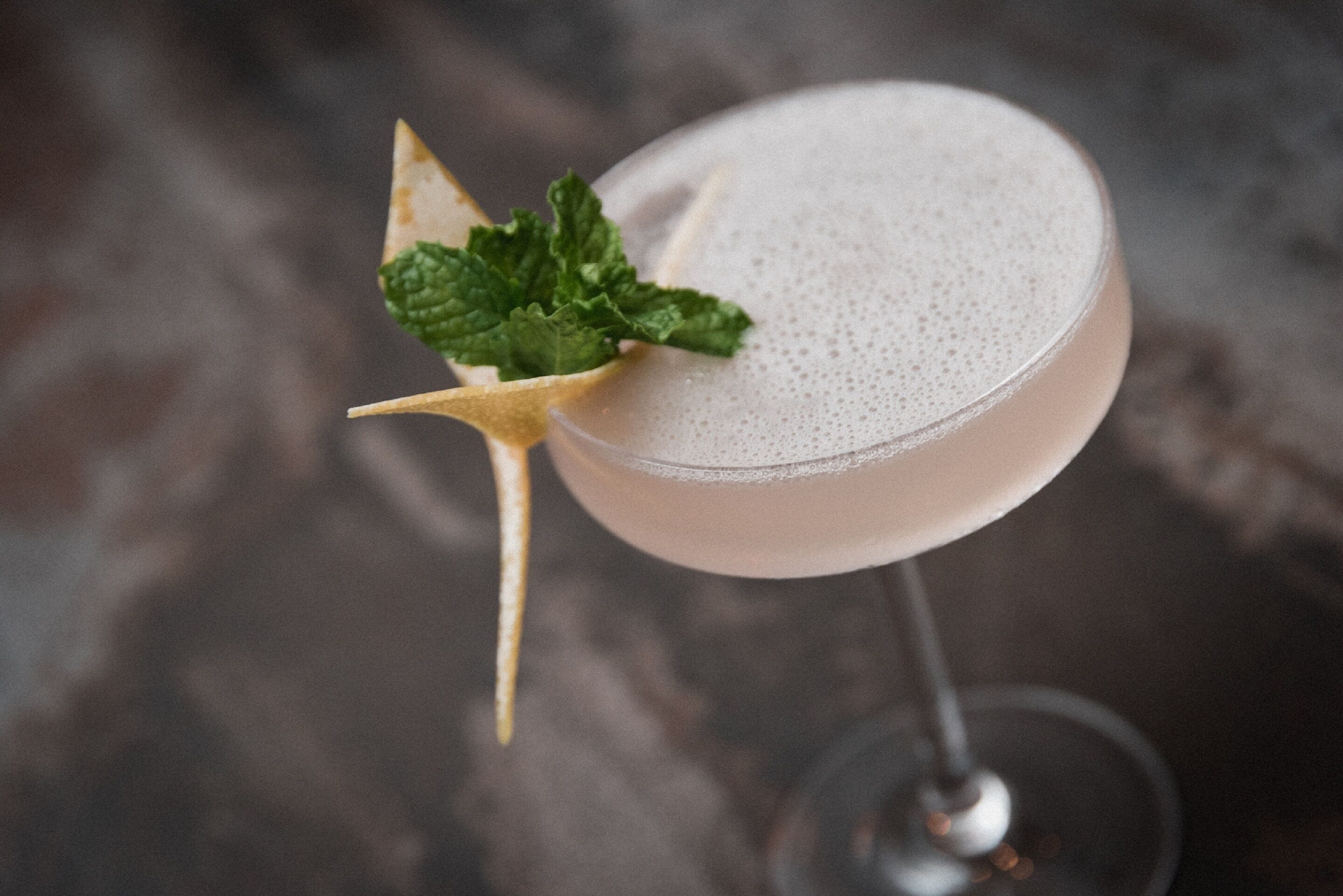 A cocktail in a stemmed glass with a garnish.