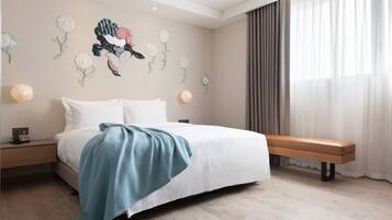 Un dormitorio con cama, un banco y detalles decorativos en la pared.