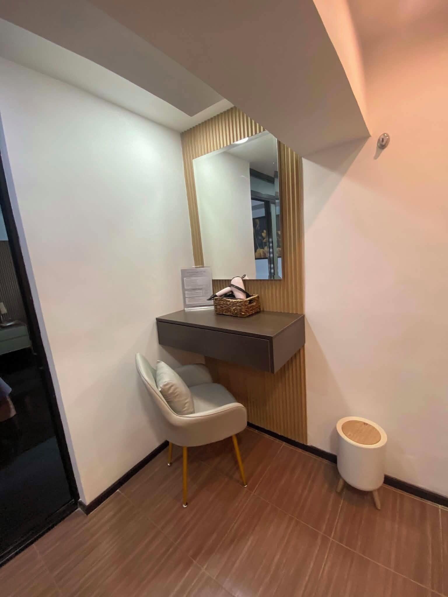 Une salle de bain avec un meuble-lavabo, un miroir, une chaise et des toilettes.