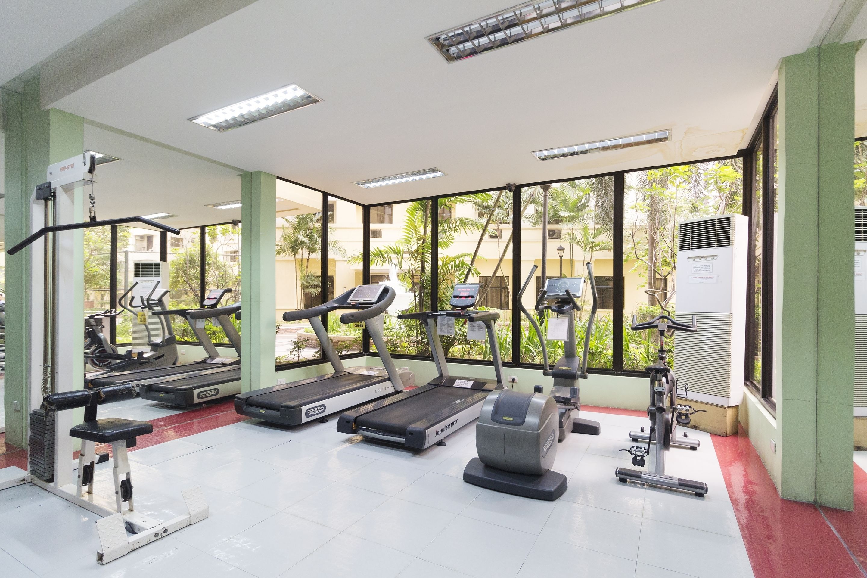 A gym with treadmills, elliptical machines, and a stationary bike.