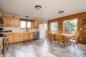 Enjoy meals in the spacious kitchen with a central island, dishwasher, and large windows offering a view of the surrounding landscape.