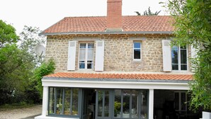 A stone house with a tiled roof, a covered porch, and a satellite dish. - 700m from Plage des Dames - House for 9 (Noirmoutier-en-l´Ile)